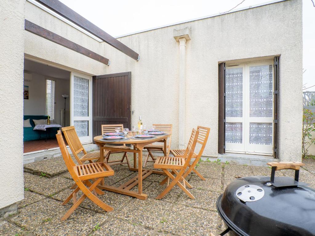 een patio met een tafel en stoelen en een grill bij Holiday Home Grau Village by Interhome in Le Grau-du-Roi