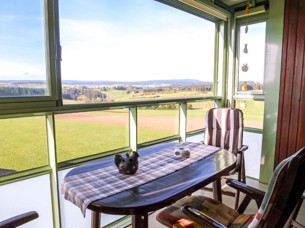 une table et des chaises dans une chambre avec une grande fenêtre dans l'établissement Apartment F 118 by Interhome, à Dittishausen