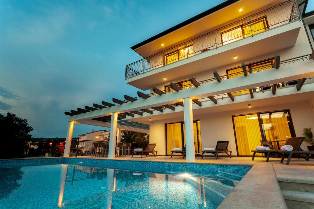 a villa with a swimming pool at night at Luxury Villa Rivabel in Malinska