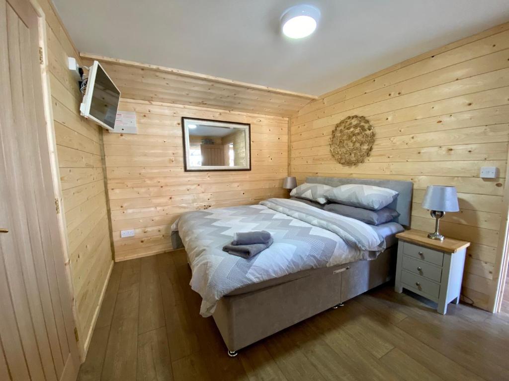 um quarto com uma cama numa parede de madeira em Southernwood - Wantage Road Lodge em Didcot