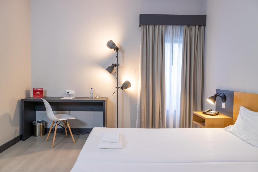 a hotel room with a bed and a desk and a chair at Flag Hotel Braga in Braga
