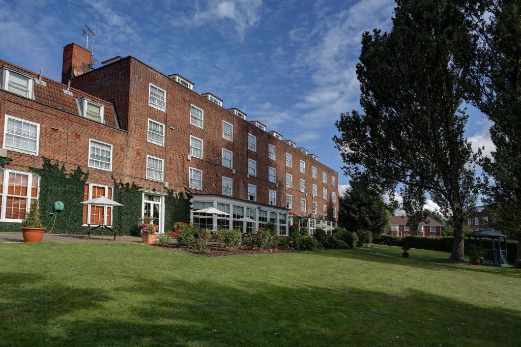 a large brick building with a clock on the side of it at Best Western Homestead Court Hotel in Welwyn Garden City