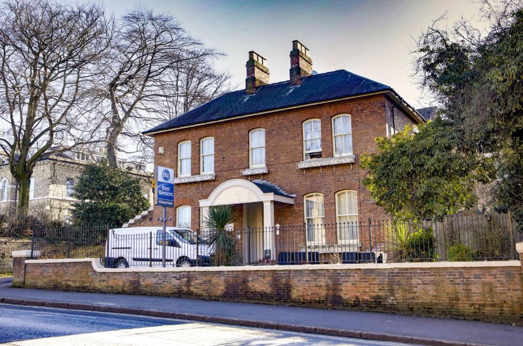 a brick house with a truck parked in front of it at Best Western Kilima Hotel in York