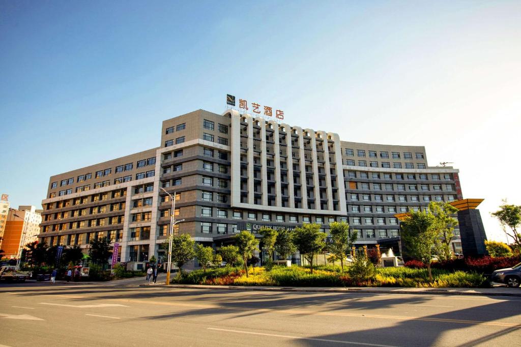 un grand bâtiment dans une ville avec une rue dans l'établissement Quality Hotel Zhangye, à Zhangye