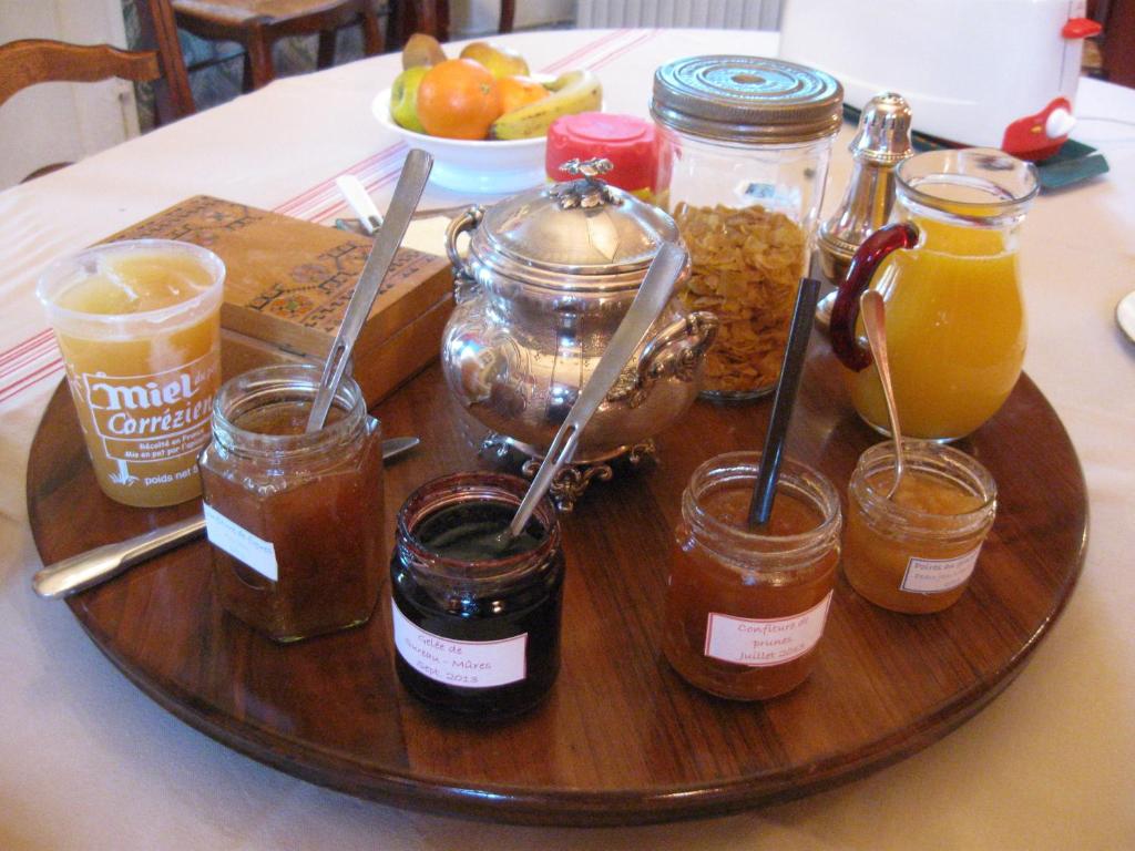 a tray with jars of food and drinks on a table at Chambres d'hôtes de charme Le Pradel in Monceaux-sur-Dordogne