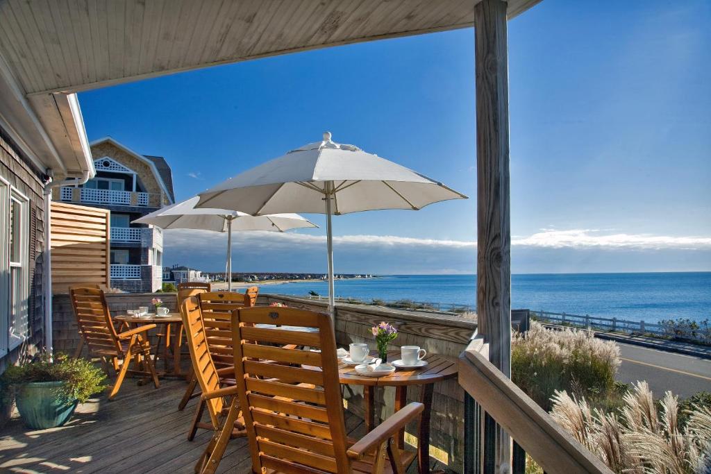 a patio with a table and chairs and an umbrella at Inn on the Sound in Falmouth