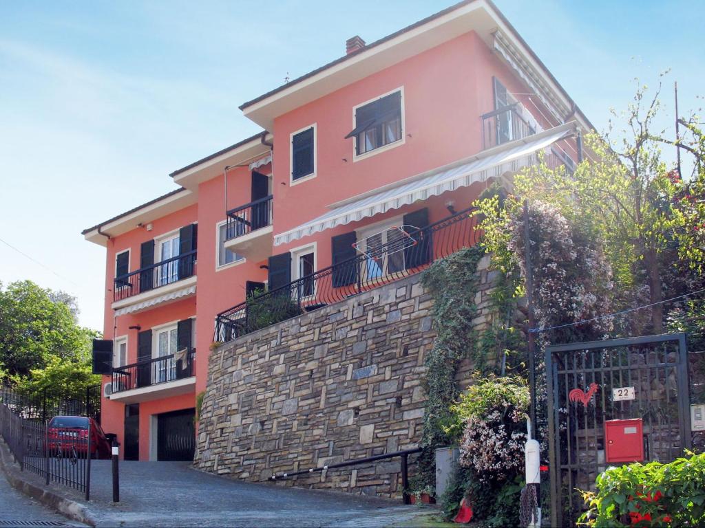 Gorleri的住宿－Apartment Degli Aranci - IMP385 by Interhome，一座粉红色的建筑,旁边设有阳台