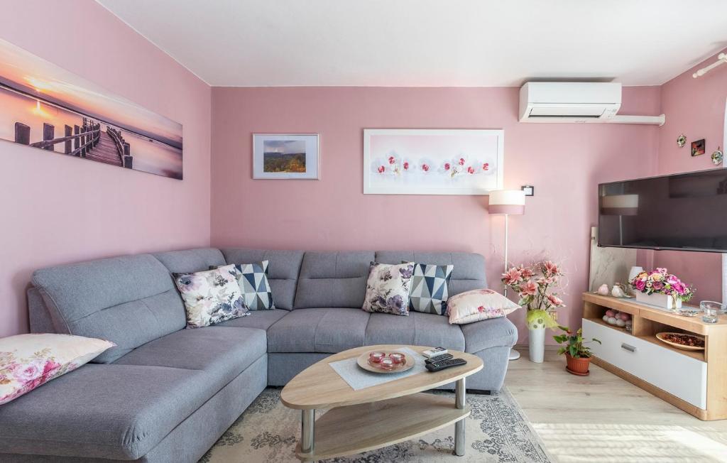 a living room with a blue couch and pink walls at Apartment Noemi in Poreč