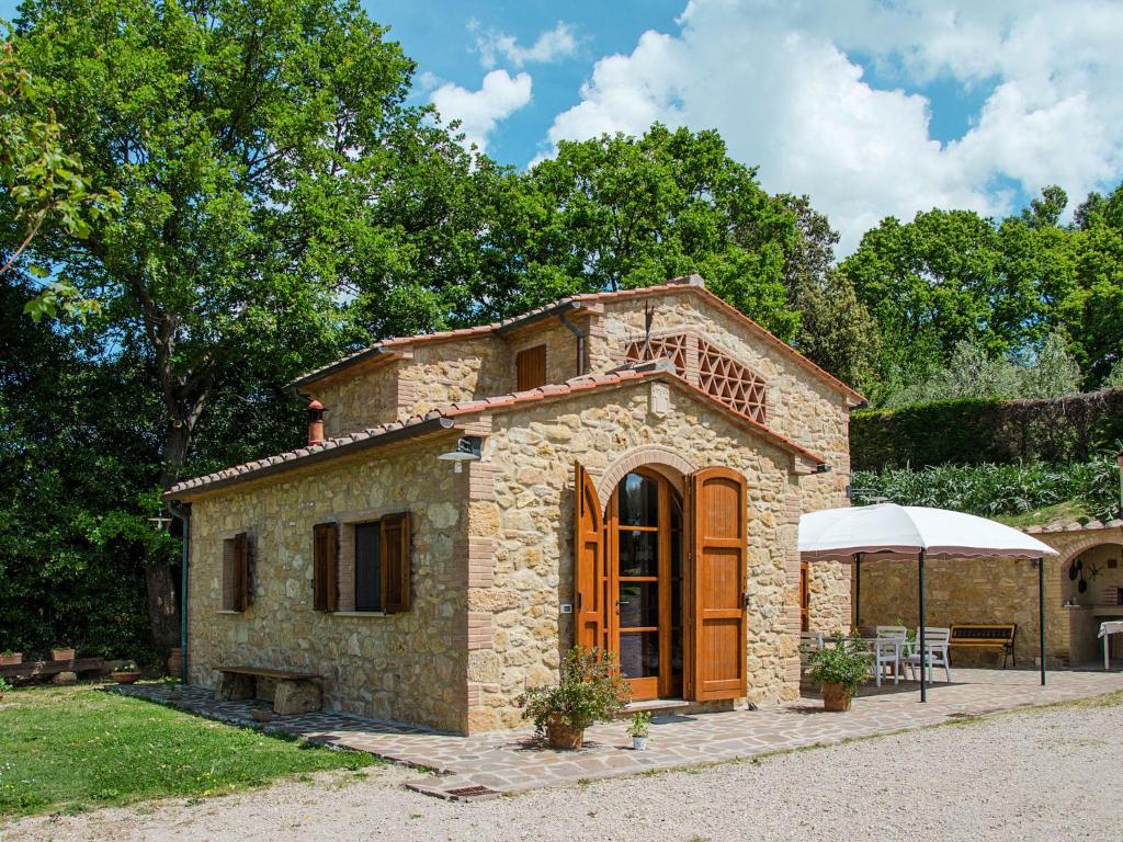 una pequeña casa de piedra con una mesa y una tienda en Holiday Home Casolare Ser Chelino by Interhome, en Volterra