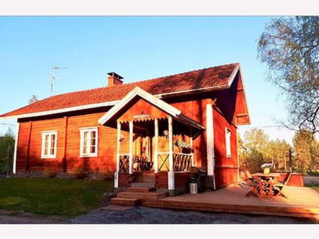 ein großes Holzhaus mit einer Veranda und einer Veranda in der Unterkunft Holiday Home Virtaan väentupa by Interhome in Nuoramoinen