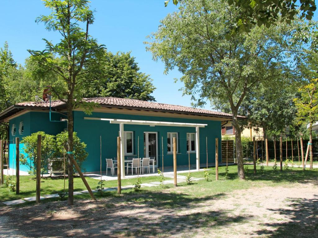 une maison bleue avec des arbres devant elle dans l'établissement Holiday Home Fior di Sole by Interhome, à Manerba del Garda