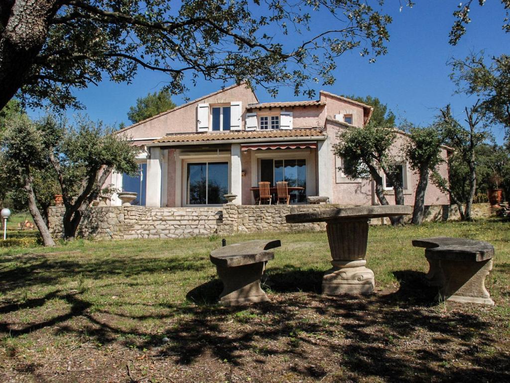 una casa con un banco de piedra delante de ella en Villa La Chênaie by Interhome, en Saumane-de-Vaucluse