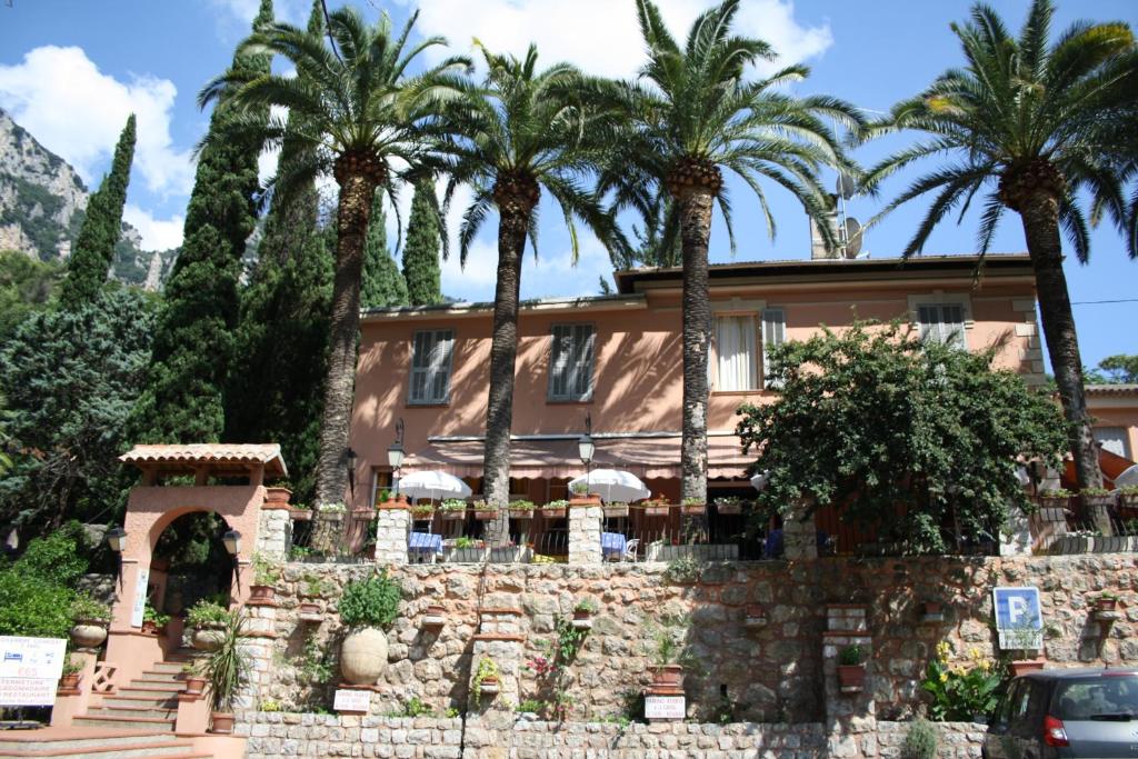 a house with palm trees in front of it at Auberge Les Gorges du Loup in Tourrettes-sur-Loup