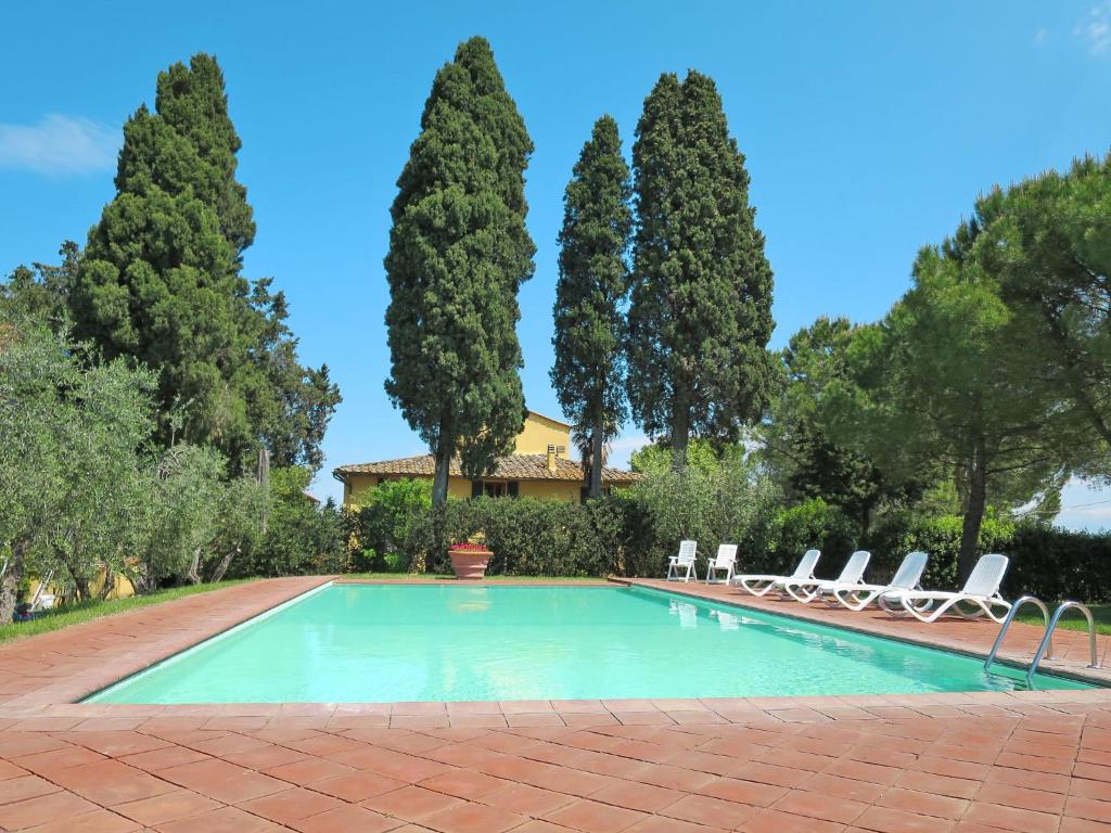 a swimming pool with lounge chairs and trees at Apartment Campiglia-3 by Interhome in Tavarnelle in Val di Pesa