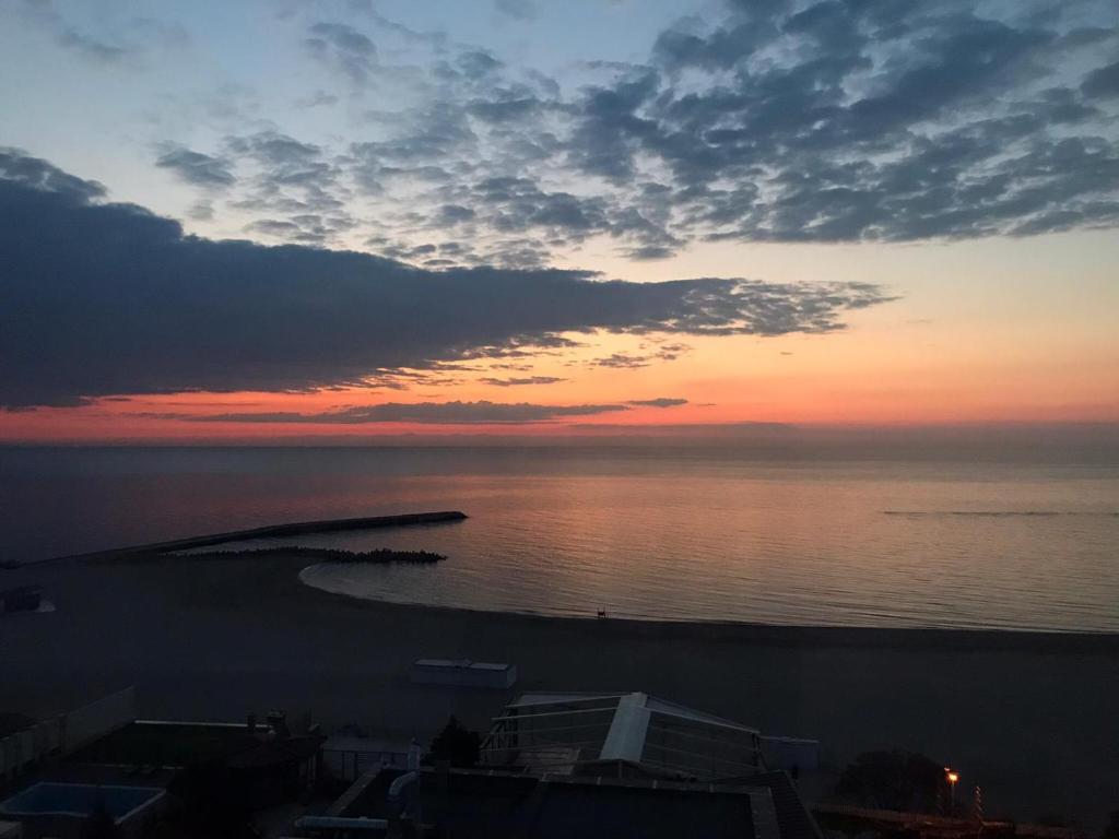 a view of the ocean at sunset at Faleza Nord Sea View Apartment in Constanţa
