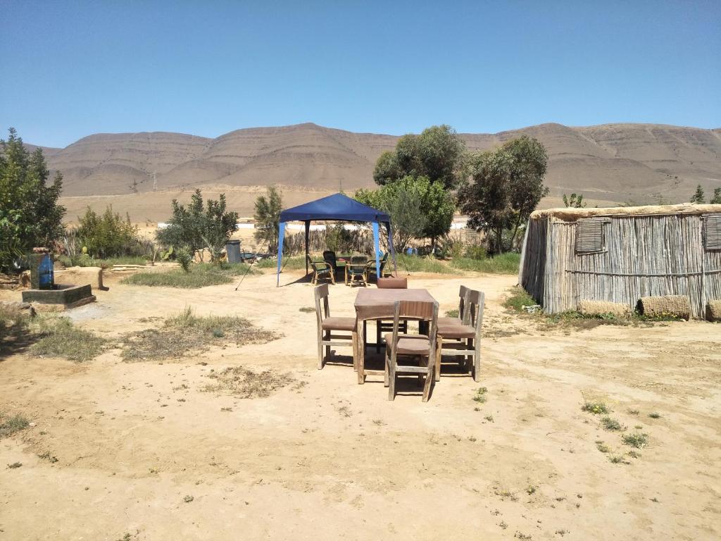 a table and chairs in the middle of the desert at Tarmguist in Tighmert