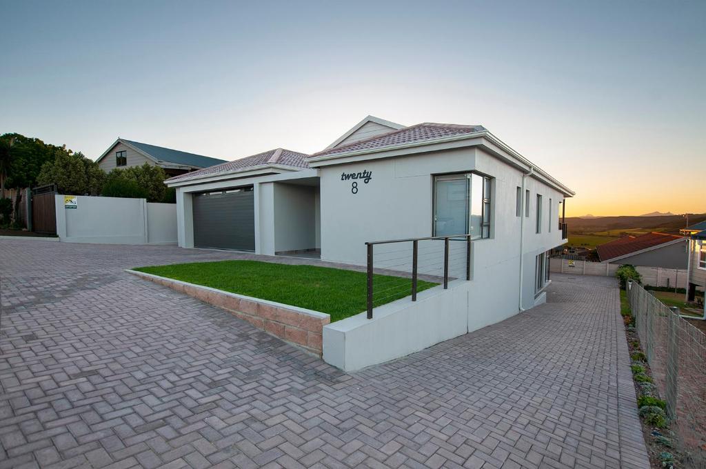 a white house with a brick driveway at The Guinea Fowl in Reebok