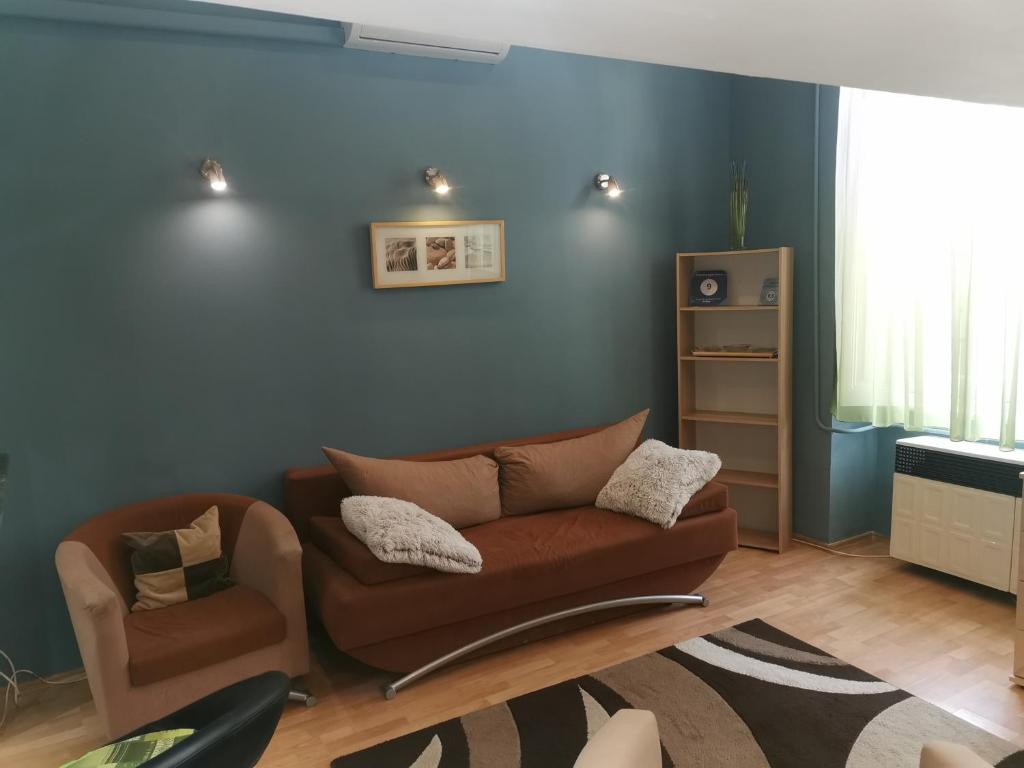 a living room with a couch and a chair at Galéria Apartman in Szeged