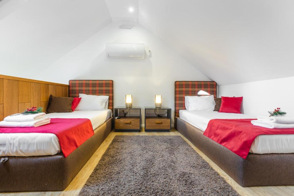 Zimmer mit 2 Betten mit roter und weißer Bettwäsche in der Unterkunft Apartman Maria - Krila Zlatibora in Zlatibor