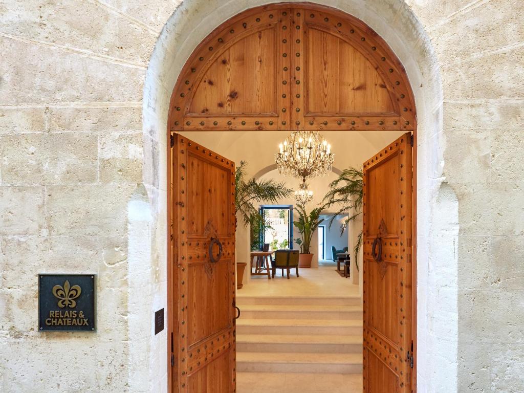 シウタデリャにあるFaustino Gran Relais & Chateauxのシャンデリア付きの家の入口