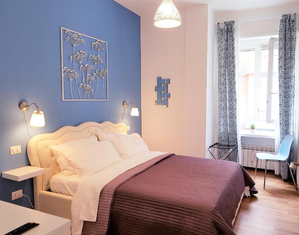 ein Schlafzimmer mit einem Bett und einer blauen Wand in der Unterkunft Sonny Capone Al Vaticano in Rom