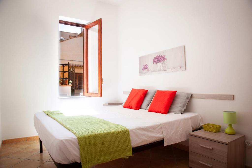 a bedroom with a bed with red and green pillows at Casa Gavi in Tre Fontane