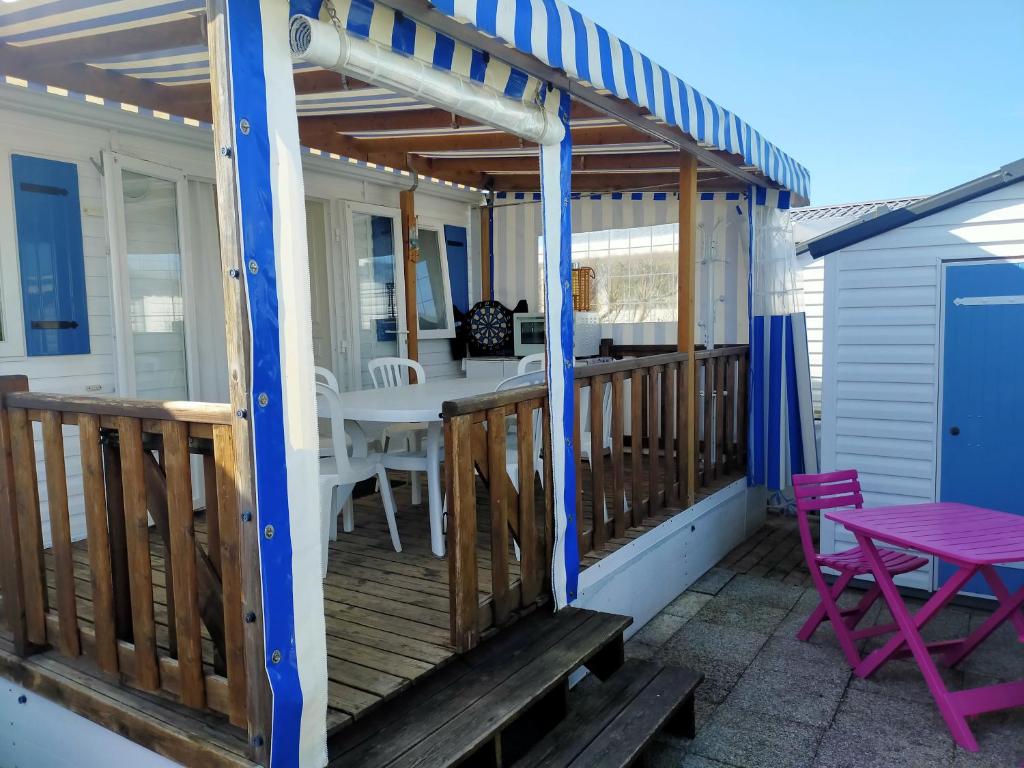 une terrasse avec une pergola, une table et des chaises dans l'établissement Camping Cap Soleil île d'Oléron 4 étoiles, à La Bétaudière