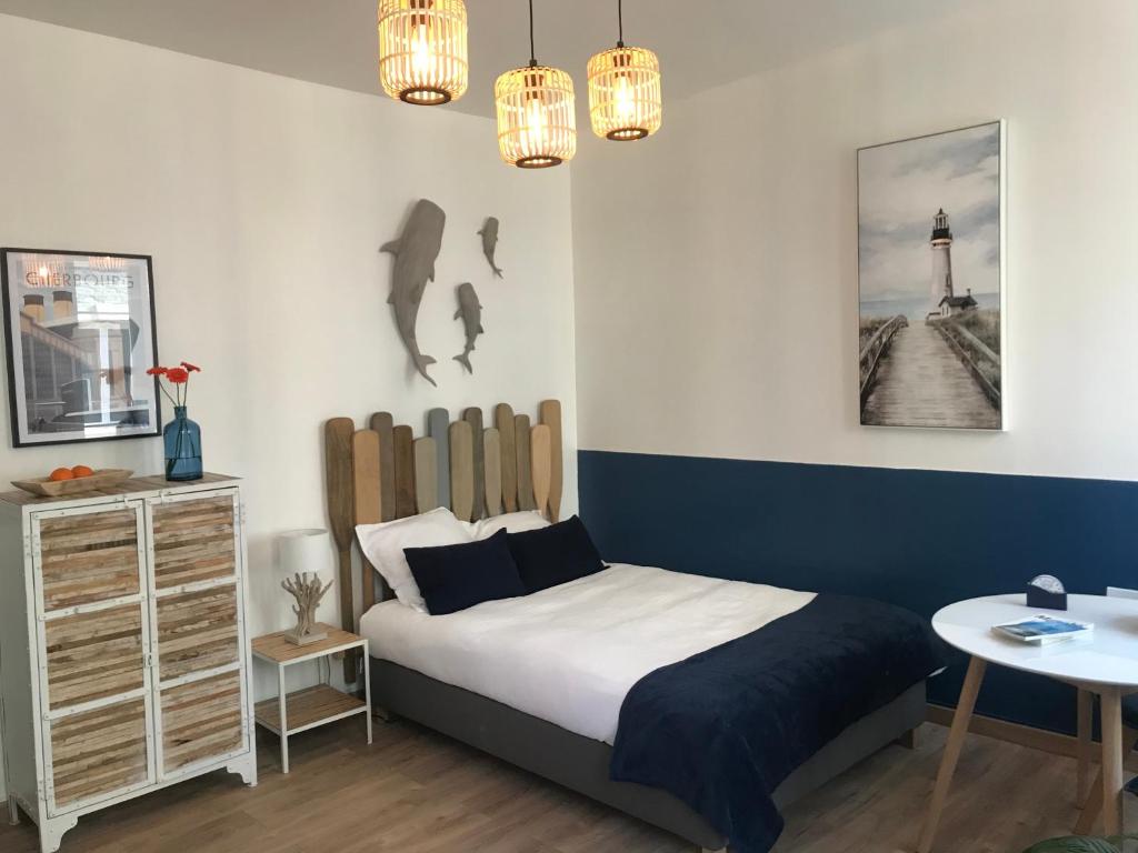 1 dormitorio con cama, mesa y faro en Cherbourg Sea Sand, en Cherbourg-en-Cotentin