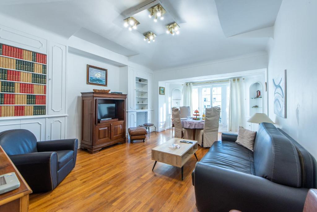 un salon avec un canapé et une télévision dans l'établissement The Queen, à Nice