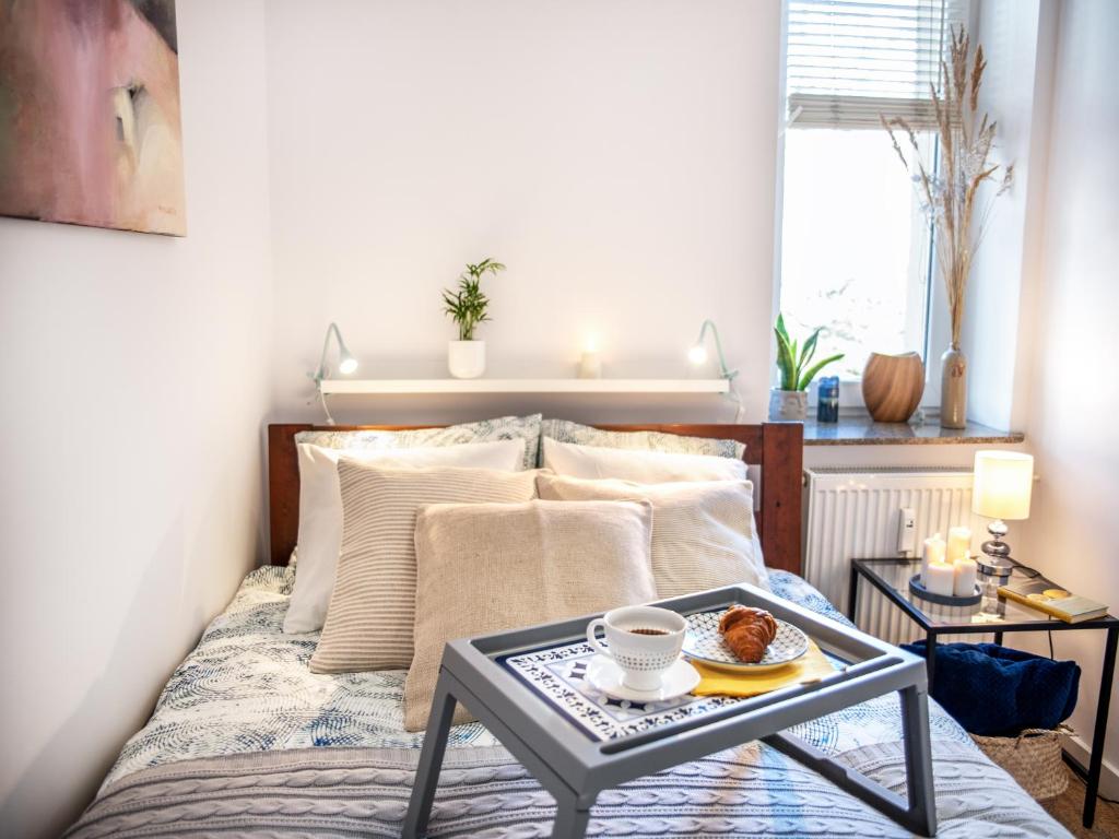 1 dormitorio con 1 cama y una bandeja de comida en una mesa en Apartament Sunset Boulevard z tarasem dla 4 gości en Gdynia