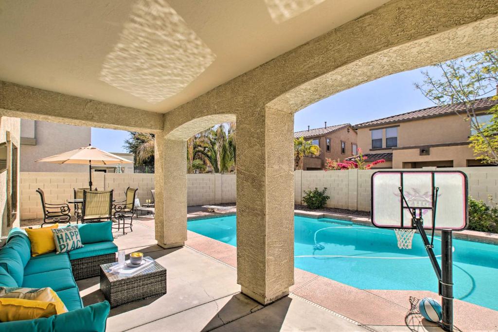 a patio with a basketball hoop and a swimming pool at Spacious Queen Creek Home with Pool and Game Room! in Queen Creek
