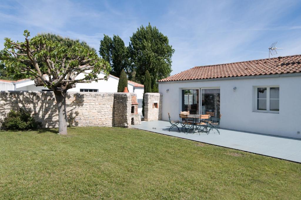 een wit huis met een tuin met een boom bij Maison Thalaos in La Flotte