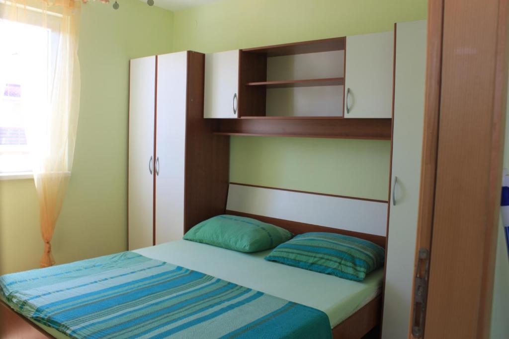a small bedroom with a bed and a shelf at Summer house in Novalja in Novalja