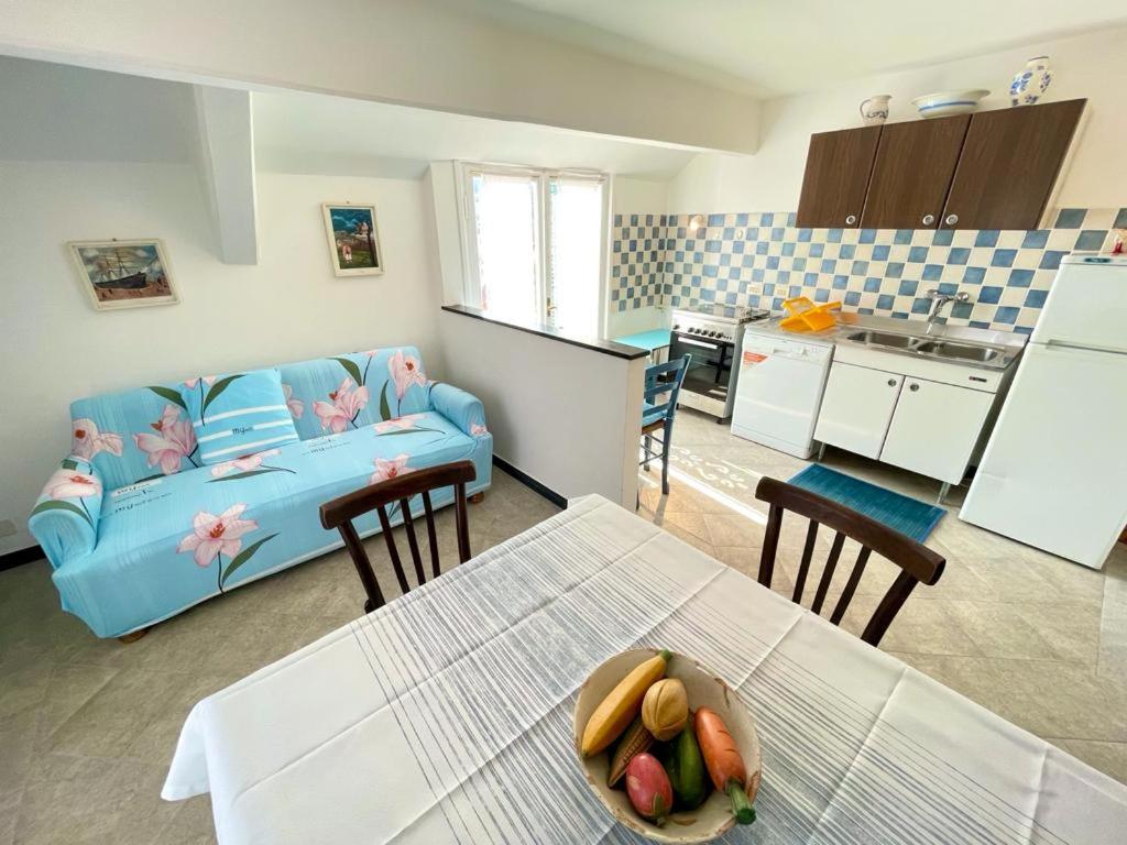a kitchen and a living room with a blue couch at Blue Sky apartment - Levanto, 5 Terre in Levanto