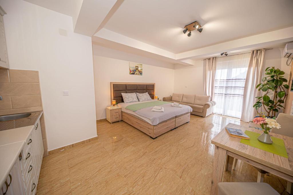 a bedroom with a bed and a living room at Skadar lake Apartments Pajovic in Virpazar