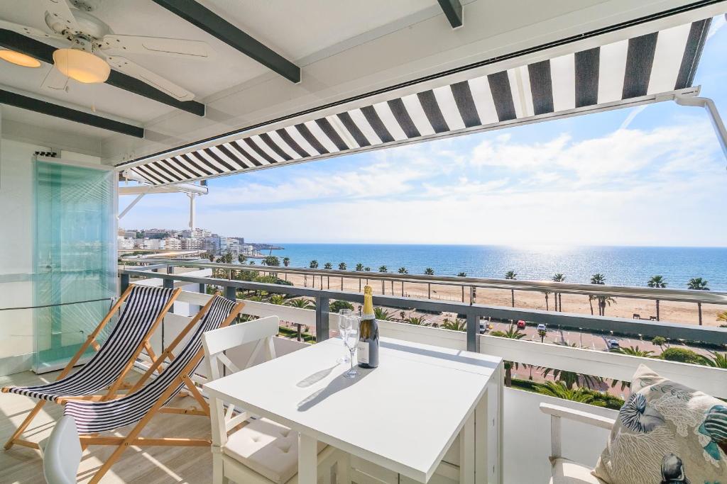 a balcony with a white table and chairs and the ocean at UHC RODAS APARTMENTS in Salou