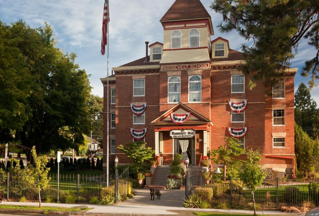 a red brick building with a flag on it at The Roosevelt Inn in Coeur d'Alene