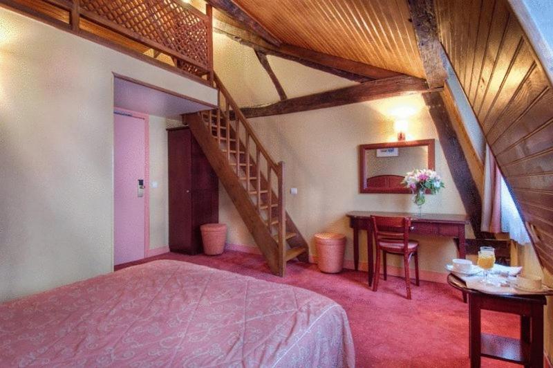 A bed or beds in a room at Hotel Le Faubourg Opera