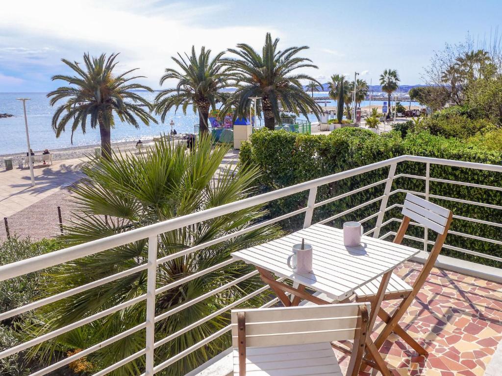 a table and chairs on a balcony overlooking the beach at Apartment Le Cormoran by Interhome in Saint-Laurent-du-Var