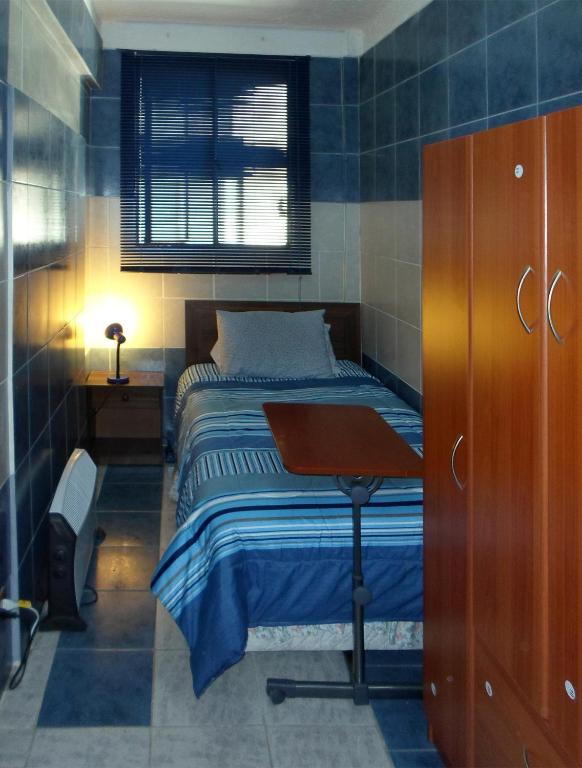 a small bedroom with a bed and a desk at AZUL marino in Santiago