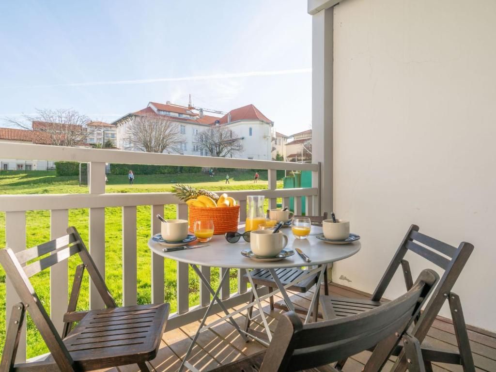 una mesa y sillas en un balcón con vistas a un campo en Apartment Chalet Louisette by Interhome, en Biarritz