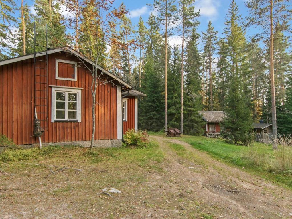 a small red cabin in the middle of a forest at Holiday Home Santerin torppa by Interhome in Iitti