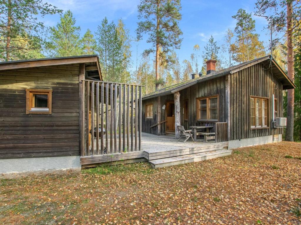 een blokhut met een veranda en een huis bij Holiday Home Honkalinna by Interhome in Isojoki