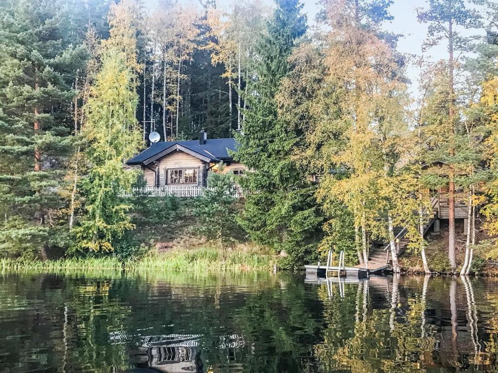 a house on a hill next to a lake at Holiday Home Miilu by Interhome in Iitti