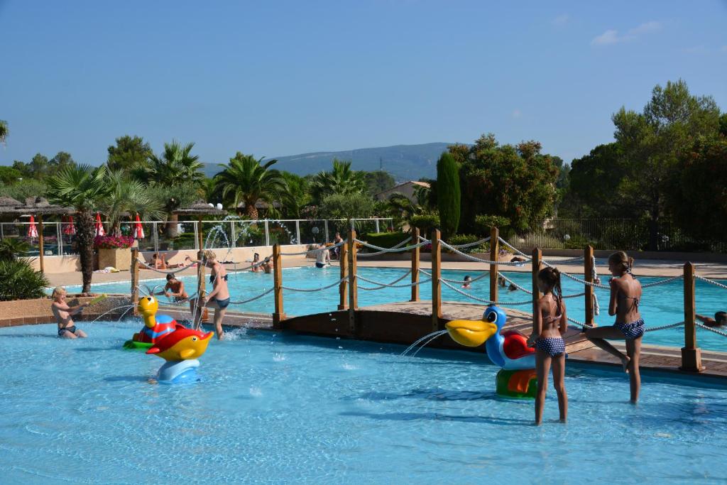 un groupe de personnes jouant dans une piscine dans l'établissement Luxe chalet voor 5 personen op Camping Leï Suves - JoyCasa, à Roquebrune-sur Argens