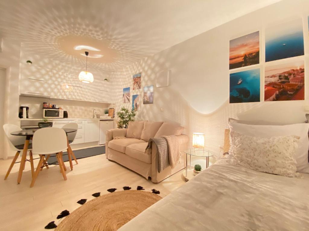 a bedroom with a bed and a couch and a kitchen at Studio Mare in Zadar