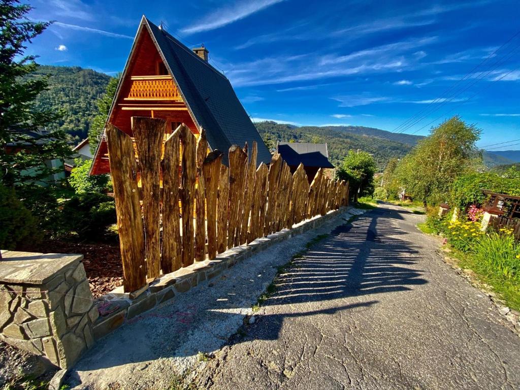 una valla de madera frente a una casa en SkiBajkowa Chata en Szczyrk