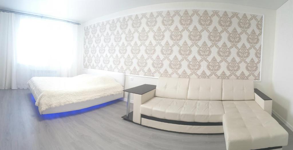 ヤロスラヴリにあるApartment on Radishcheva 10/12のベッドルーム(白いベッド1台、白いソファ付)