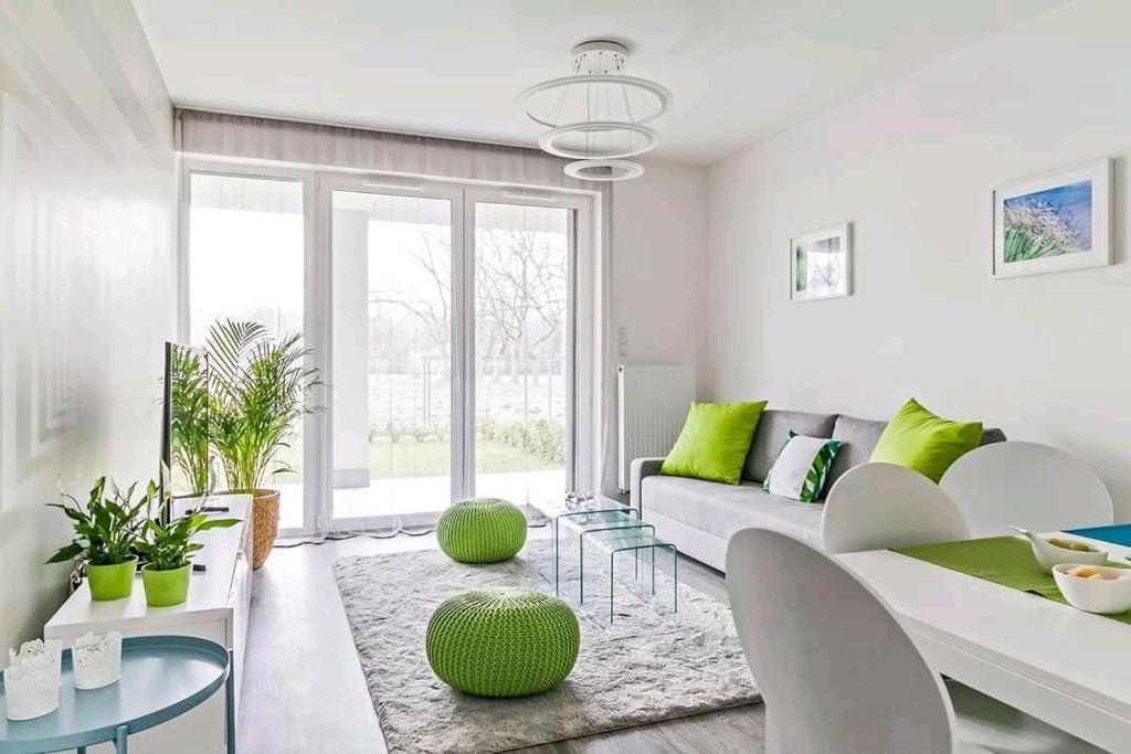 uma sala de estar com um sofá e toques verdes em Green Apartman Balatonlelle em Balatonlelle