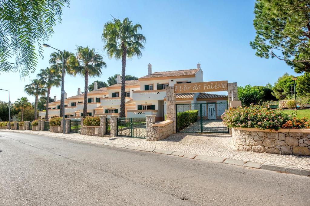 a building with a fence in front of a street at Flor da Falésia Villas in Albufeira